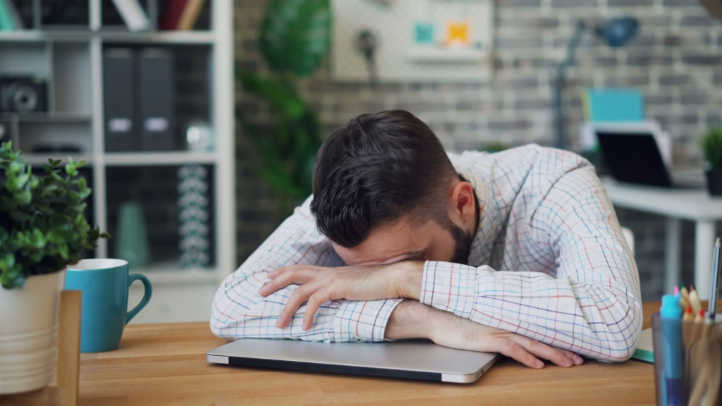 A very burnt out man at work. In this article we review how to recover from burnout.